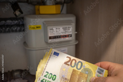 next to a gas meter is held a lot of two hundred euro banknotes photo