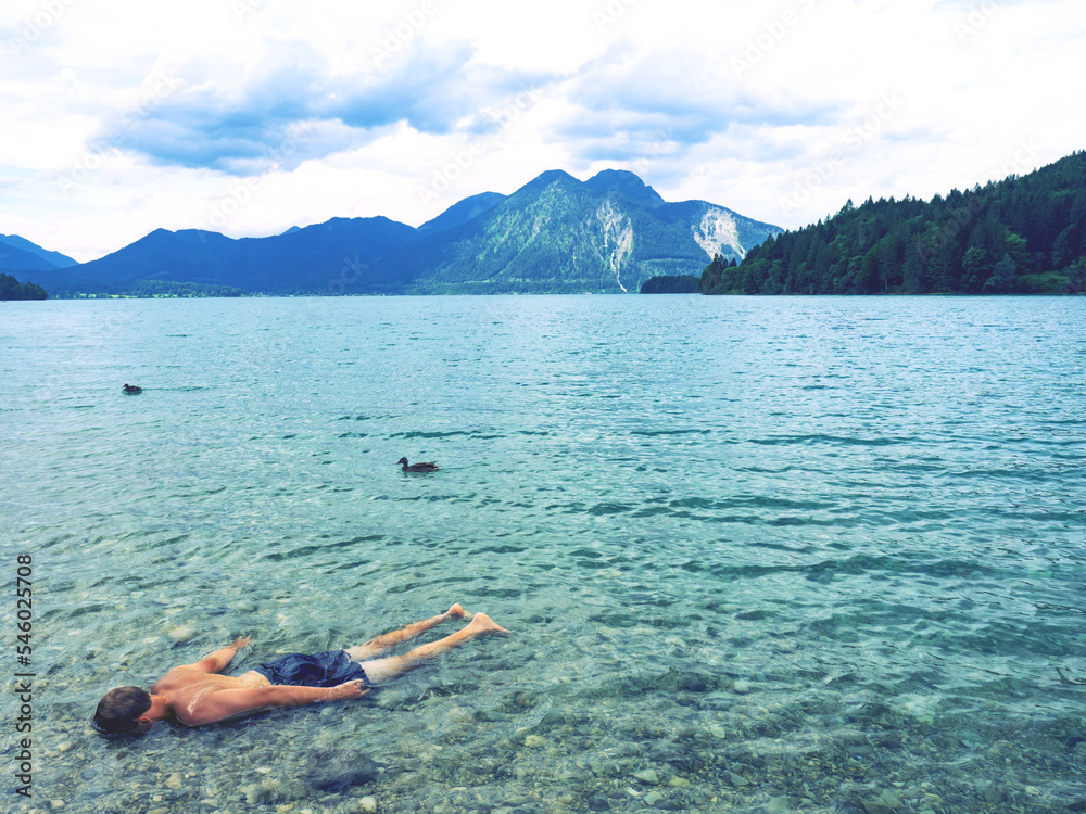 Athletic teenager boy shows how a drowned body floats in low water ...