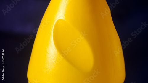 Botella de plástico amarillo con tapón azul de producto de limpieza