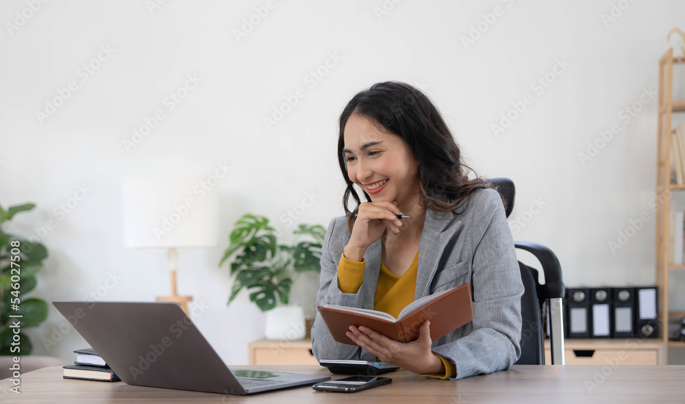 Portrait of an Asian young business Female working on a laptop computer in her workstation.Business people employee freelance online report marketing concept. Portrait of an Asian young business Female working on a laptop computer in her workstation.Business people employee freelance online report marketing concept.