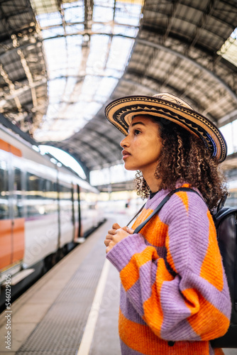 Wallpaper Mural Young black woman traveler with backpack in the railway, Backpack and hat at the train station with a traveler. Torontodigital.ca