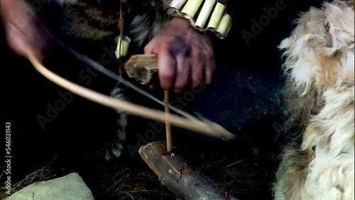 Ancient people make fire by rubbing one piece of wood against another. Tribe of primitive people.