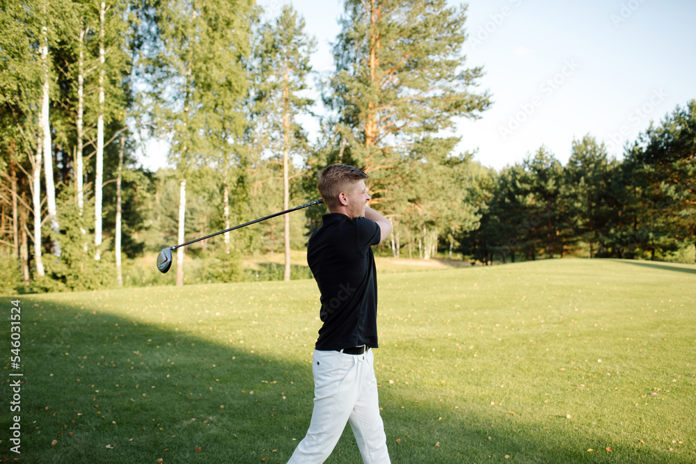 Male athlete plays golf on the field. Strong hit on the ball. High quality photo