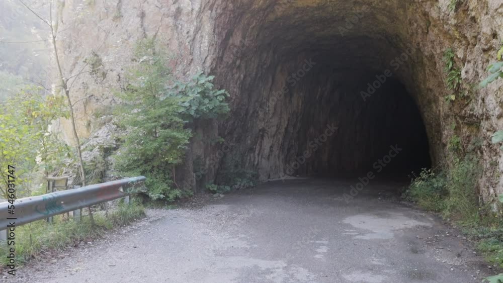 An old abandoned highway in the mountains. Collapses of rocks and trees, rockfalls on the road. Rocks, mountain gorge. Open road tunnels. Damaged bumpers on the side of the road. An old abandoned highway in the mountains. Collapses of rocks and trees, rockfalls on the road. Rocks, mountain gorge. Open road tunnels. Damaged bumpers on the side of the road.