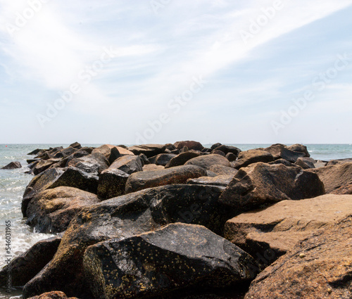 Rock jetty sticking out into the ocean with copy space above © coachwood