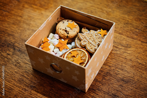 Christmas Homemade Sweet Hampers. Christmas Sweet Gift Box. Festive treats Gift Hamper Idea for Adults and Kids. Box with Homemade different cookies and orange slices photo