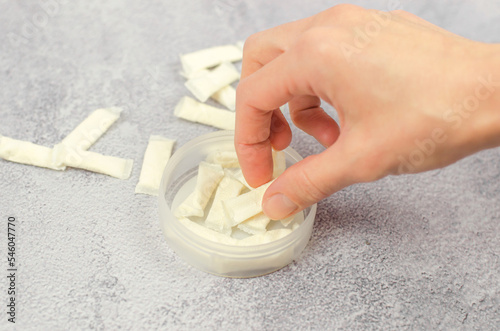 A woman's hand takes Swedish snus from a box, close-up