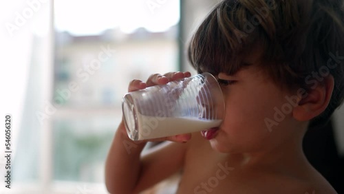 Small boy drinks milk. Closeup child face gulping high protein beverage rich in vitamin