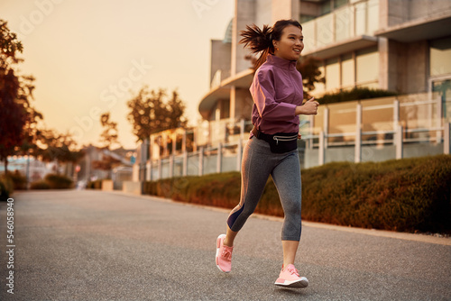 Full length of Asian sportswoman running on street.