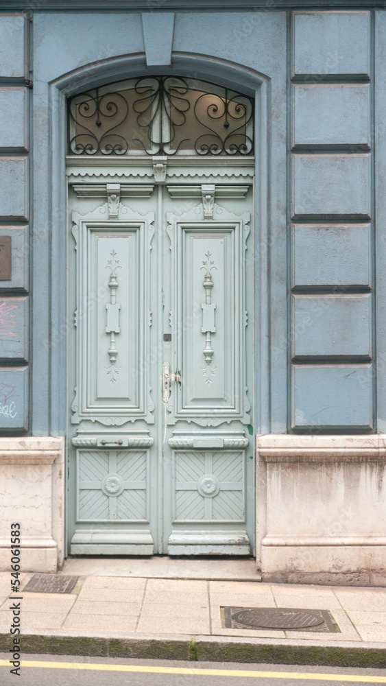 Puerta de madera color azul palo con adornos esculpidos