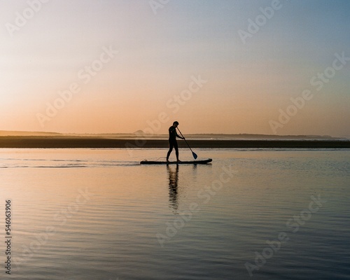 Paddle Boarder on The Beach © Studio Brooks/Wirestock Creators