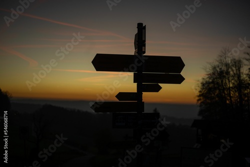 Selective focus shot of direction signs against the sunset