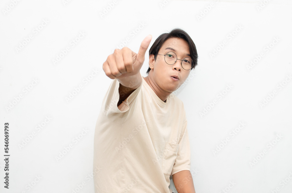 handsome attractive Asian man smiling happily and giving thumbs up as compliment isolated over white background. man giving approval and compliment by gesturing thumbs up. handsome attractive Asian man smiling happily and giving thumbs up as compliment isolated over white background. man giving approval and compliment by gesturing thumbs up.