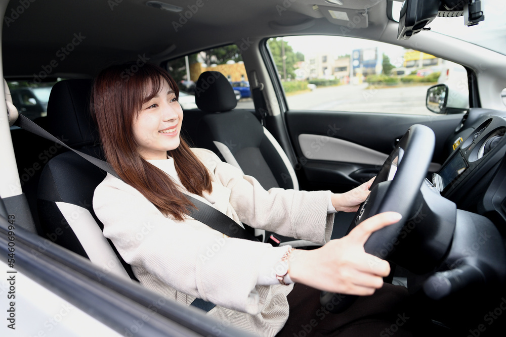 笑顔で運転をする若いアジア人女性
笑顔で運転をする若いアジア人女性