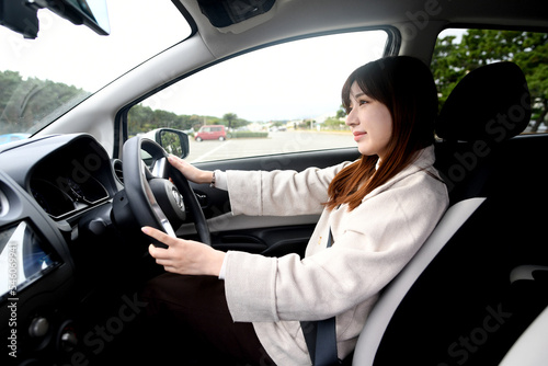 笑顔で運転をする若いアジア人女性
