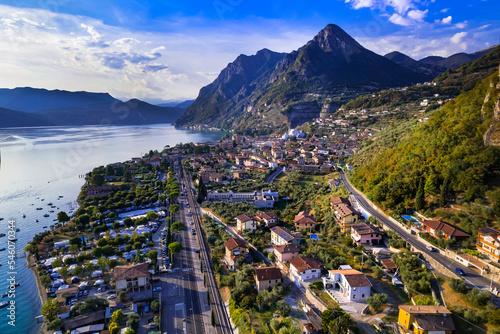 Scenic mountains and beautiful lakes of Italy - aerial drone view of Iseo lake and village over sunset. Brescia province