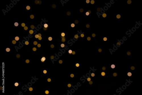 Abstract golden yellow circular blurred bokeh lights for a festive background. Defocused image.