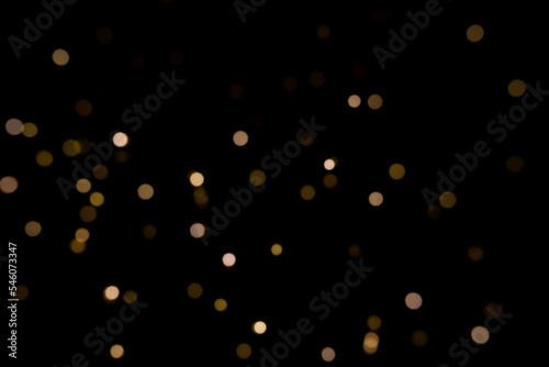 Abstract golden yellow circular blurred bokeh lights for a festive background. Defocused image.