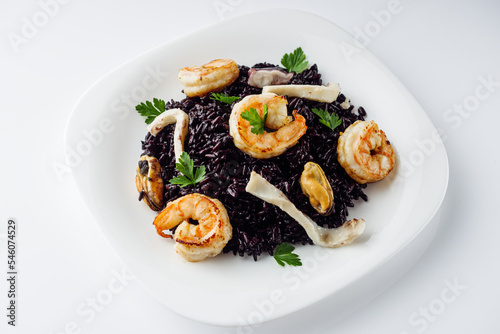 delicious black rice with shrimps and seafood on a white background