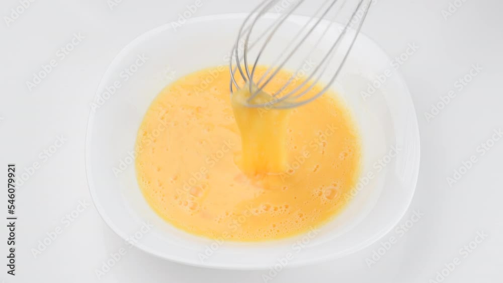 Stirring eggs with whisk, isolated on white background Stirring eggs with whisk, isolated on white background