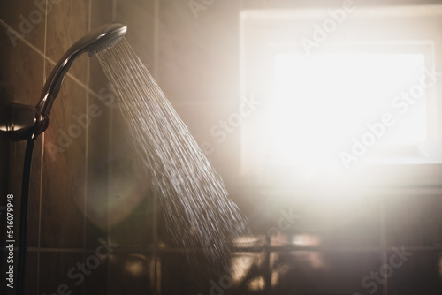 shower with flowing water and steam with window on background. 