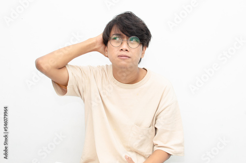 asian man looks depressed and messed up. Irritated man bites lips and scratches head. stressed over work concept.