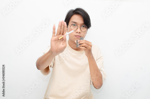 stop smoking start vaping concept. Cigarette vs e-cigarette concept. asian man holding cigarette and vape. quitting smoke concept. smoking versus vaping concept.