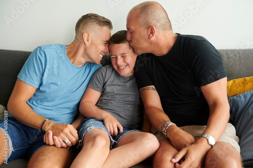 Same sex male couple kissing their son. photo