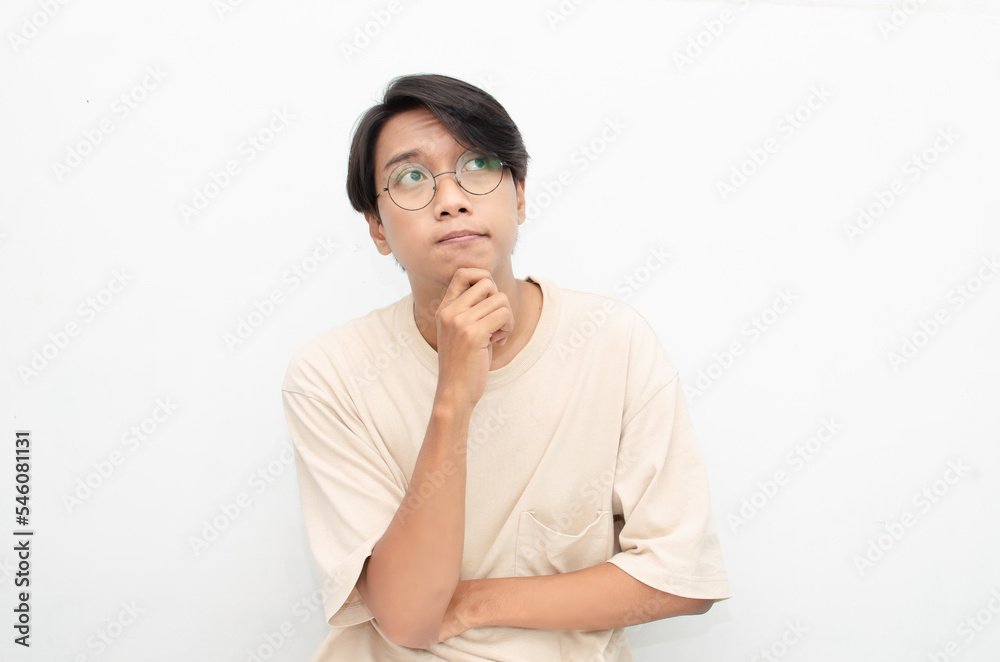 Thoughtful confused asian man thinking and wondering to choose something isolated over white background. man feeling uncertain and unsure. Thoughtful confused asian man thinking and wondering to choose something isolated over white background. man feeling uncertain and unsure.