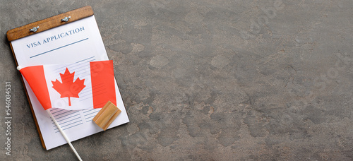 Photography Visa application form, stamp and Canadian flag on grey background with space for text