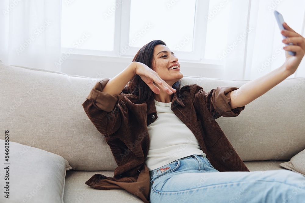 Woman blogger with phone lies at home on the couch and works freelancer online, selfie Woman blogger with phone lies at home on the couch and works freelancer online, selfie