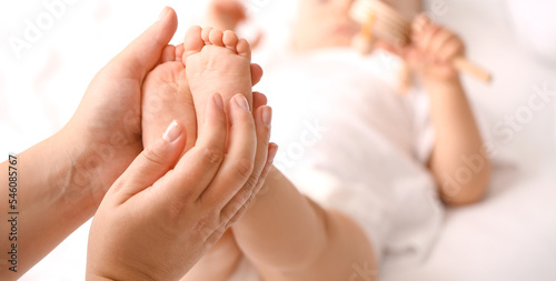 Mother massaging her baby s feet  closeup