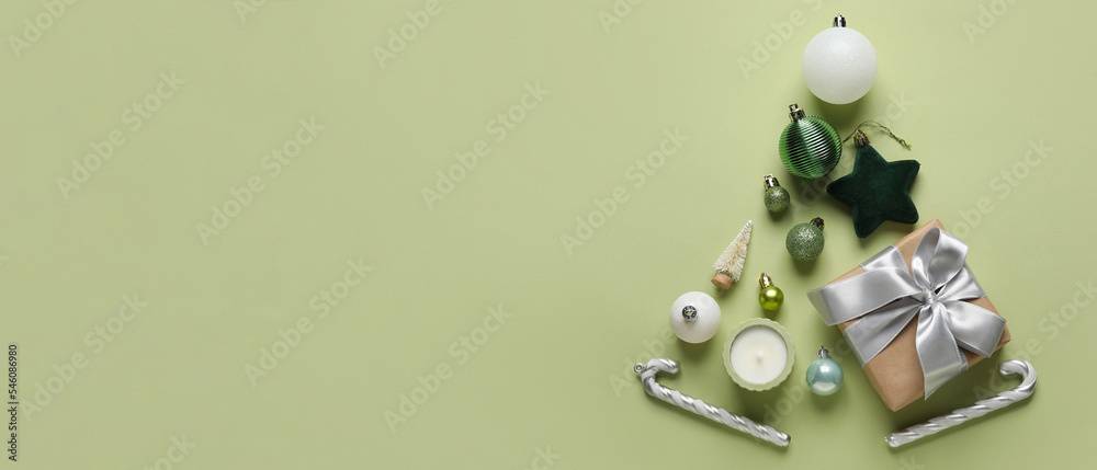 Obraz premium Christmas tree made of decorations, gift and candle on green background with space for text