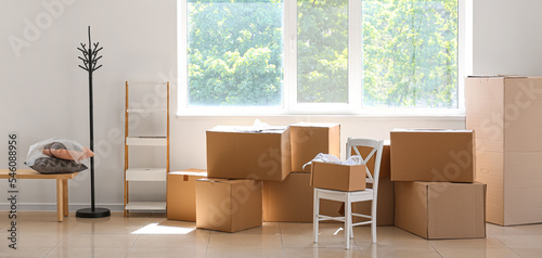 Cardboard boxes with belongings and furniture in new office on moving day © Pixel-Shot
