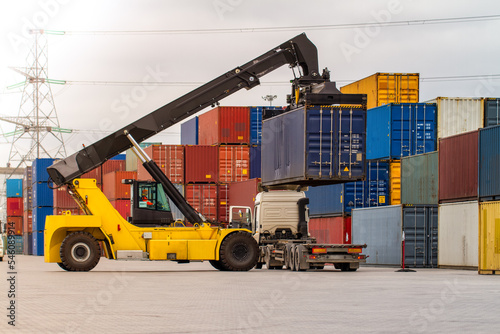 Forklift handling cargo container. Freight container loading. Container handler. Logistics import export concept. Industrial container logistic yard.