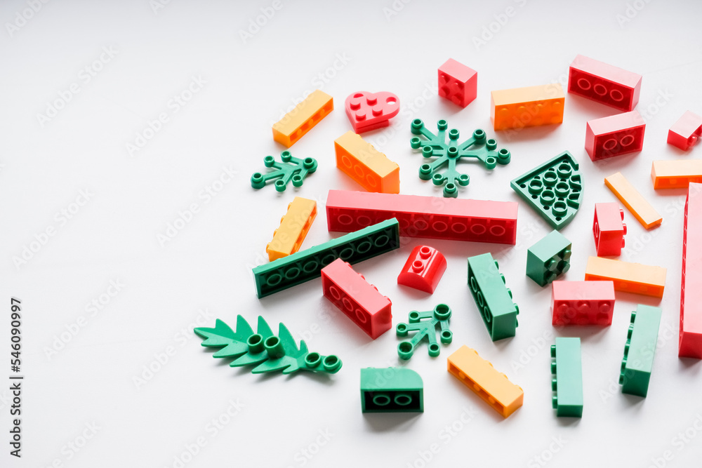 Colorful plastic building blocks flat lay on white background. Child developing game. Developing children games mockup. Colorful plastic bricks.copy space