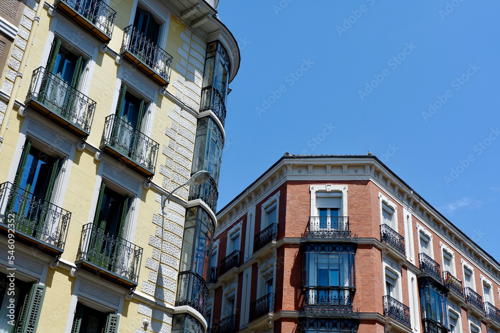 Urban classical buildings with windows and balconies downtown in Chueca district, centre of Madrid, Spain