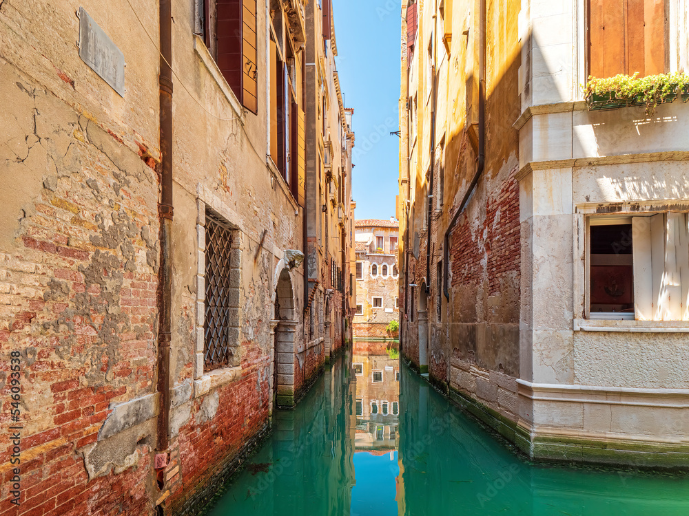 Antique Architecture Walls in Venezia with a clear canal water during summer