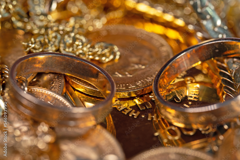 Goldschmuck, Goldmünzen und Goldbarren in einer Nahaufnahme Goldschmuck, Goldmünzen und Goldbarren in einer Nahaufnahme