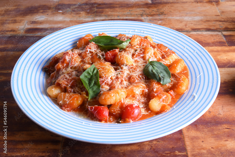 pasta in red sauce with parmesan cheese, tomato, basil, herbs, delicious food from Italian and French cuisine