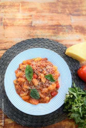 pasta in red sauce with parmesan cheese, tomato, basil, herbs, delicious food from Italian and French cuisine photo