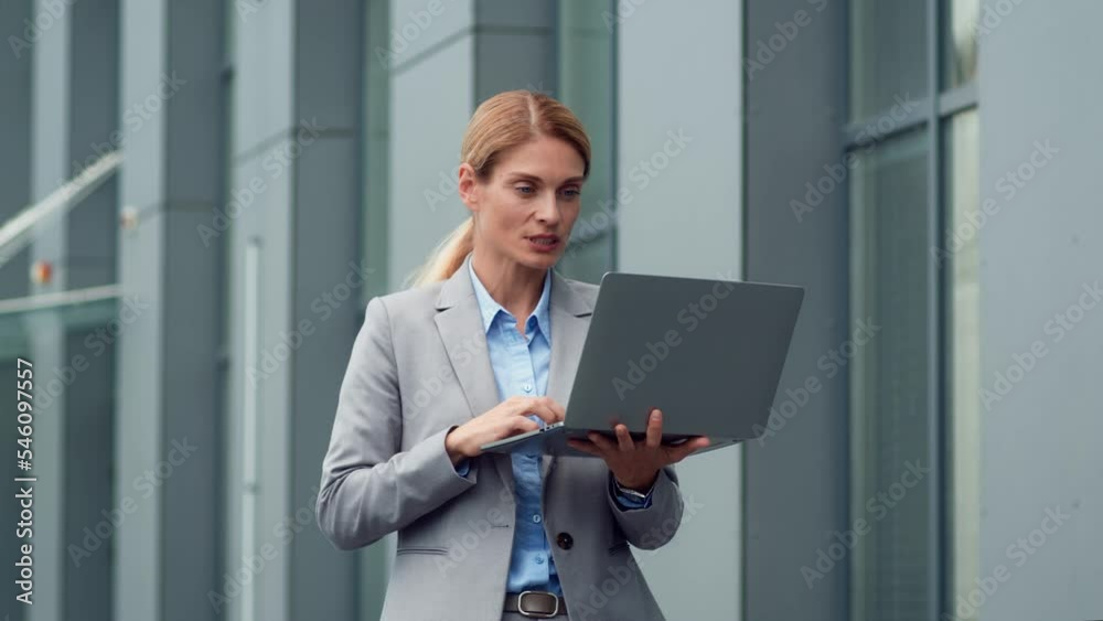 Confident middle aged business lady waving hand to laptop greeting her partners, video chatting online, free space Confident middle aged business lady waving hand to laptop greeting her partners, video chatting online, free space