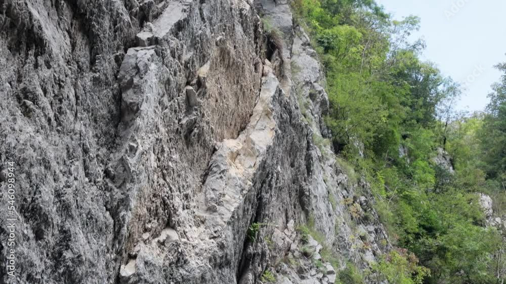 An old abandoned highway in the mountains. Rock and tree collapses, rockfalls on the road. Rocks, mountain gorge. Damaged bumpers on the side of the road. An old abandoned highway in the mountains. Rock and tree collapses, rockfalls on the road. Rocks, mountain gorge. Damaged bumpers on the side of the road.