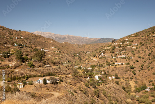 A Spanish mountain valley peppered with white stone walled houses. The area is near Arenas in the mountains of Andalusia near Malaga 