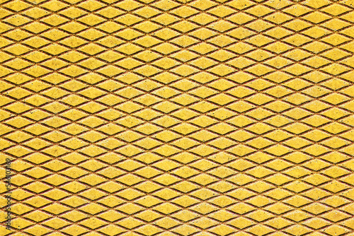 Metal grid walkway. Grunge steel mesh texture. Heavy iron backdrop pattern. Industrial grate design background. Yellow color metal. Rust texture.