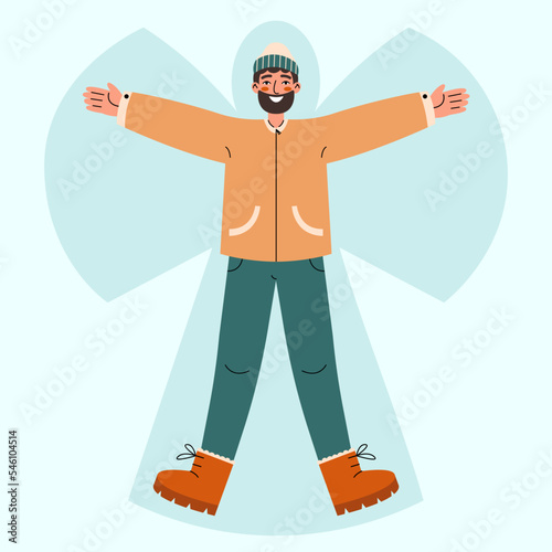 Young man lying in snow on back and moving arms and legs. Smiling man making snow angel. Winter entertainments concept.
