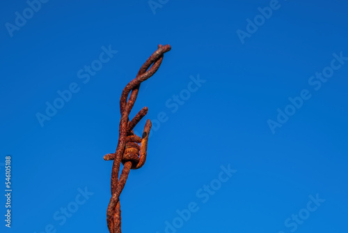 rusty barbed wire on blue sky