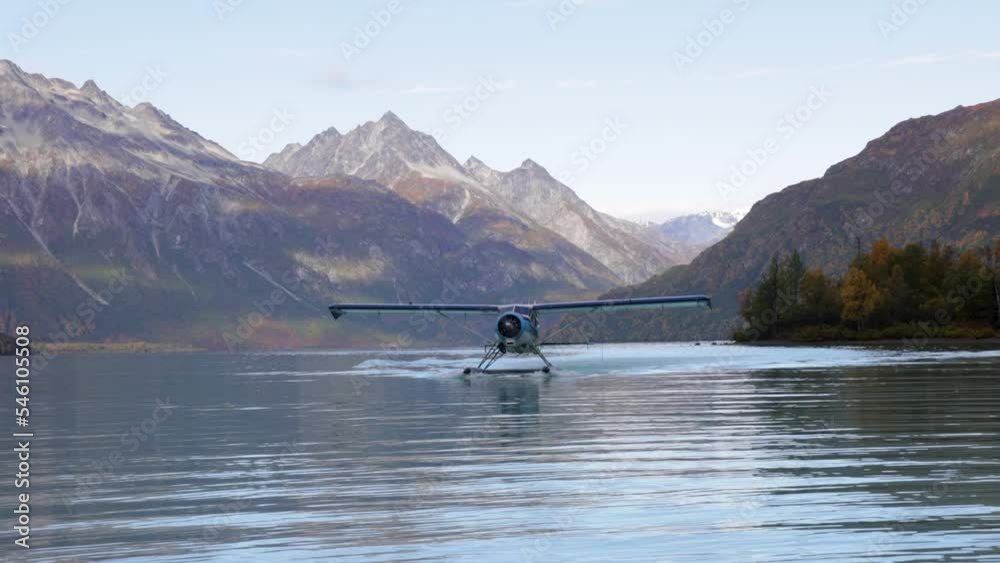 float plane lands on water in alaska in mountain range area near by homer cool avaition plane for travel etc