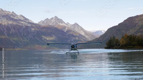 float plane lands on water in alaska in mountain range area near by homer cool avaition plane for travel etc