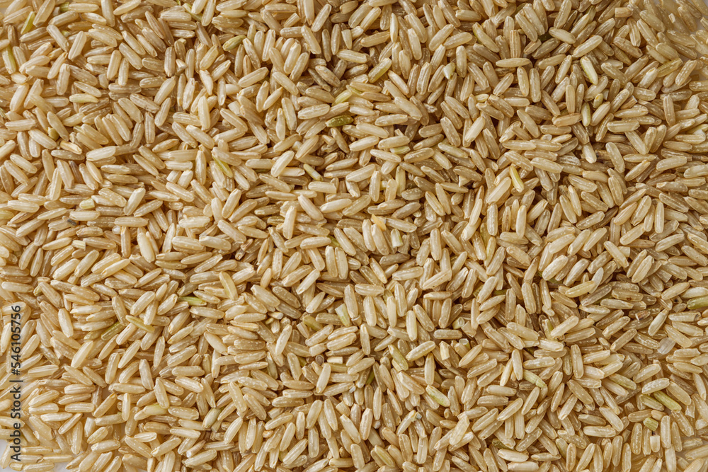 raw unpolished rice on a white acrylic background raw unpolished rice on a white acrylic background